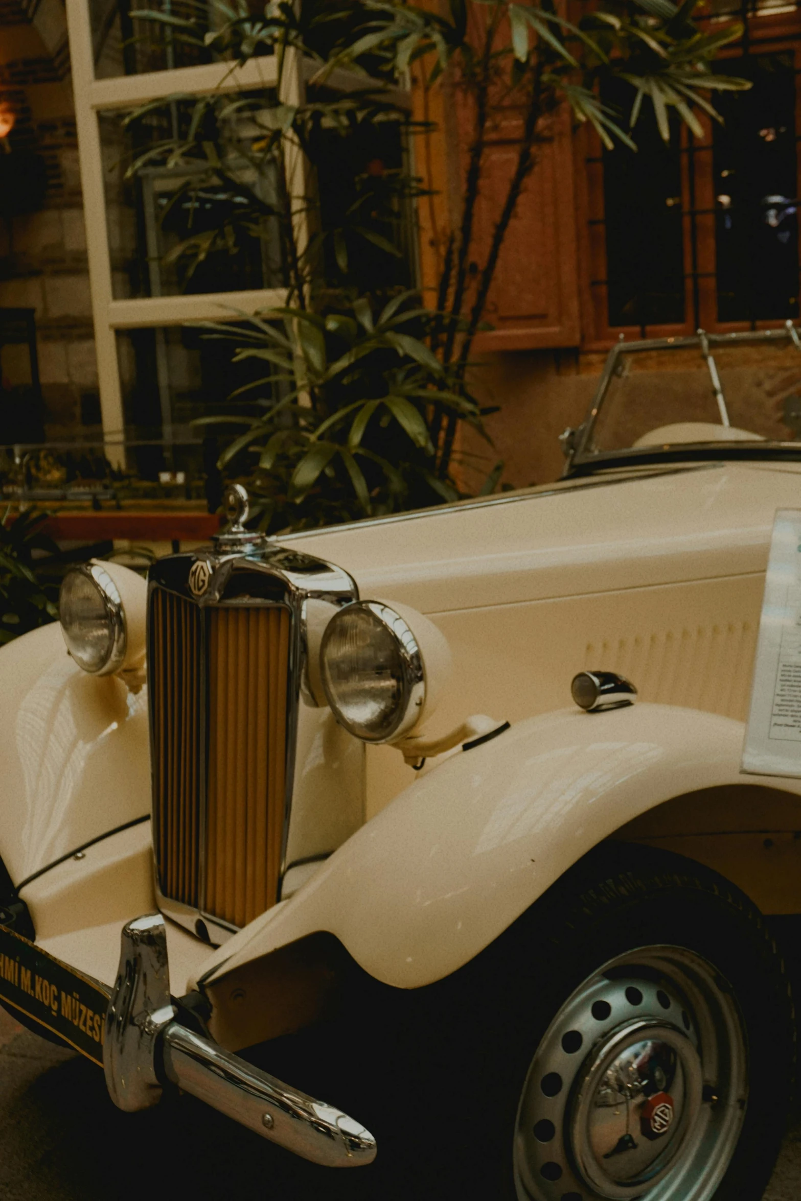 an old antique automobile is parked in front of some trees