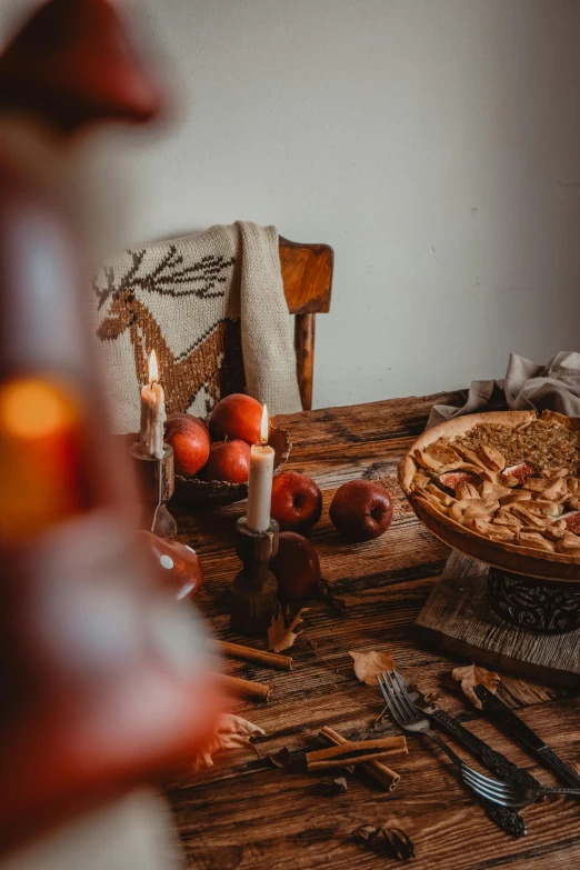 an apple pie sits on a table in the middle of a thanksgiving meal