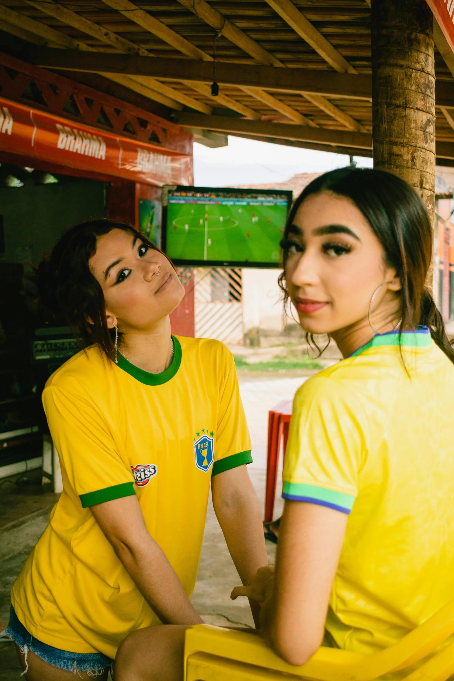 a girl standing in front of another girl wearing a yellow uniform