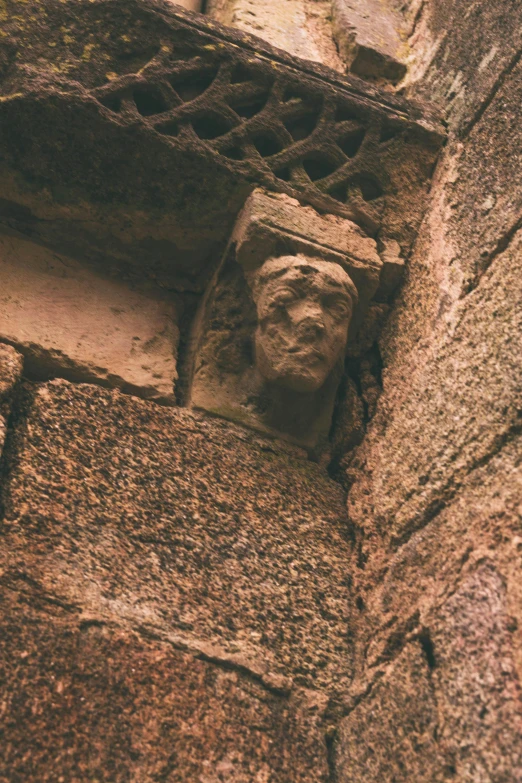 an ancient statue of a man is shown on a brick wall