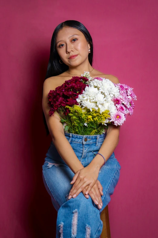 a woman sitting on a chair holding some flowers