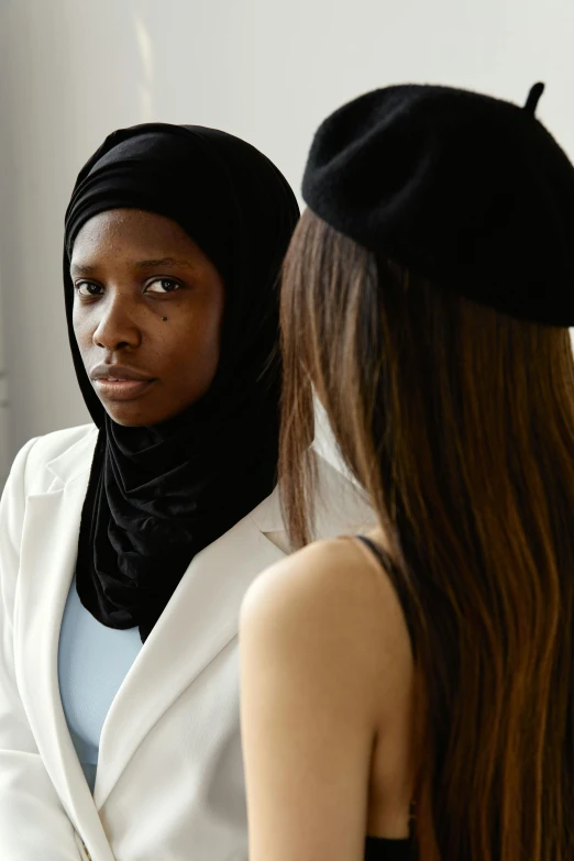 a young woman standing next to another young woman