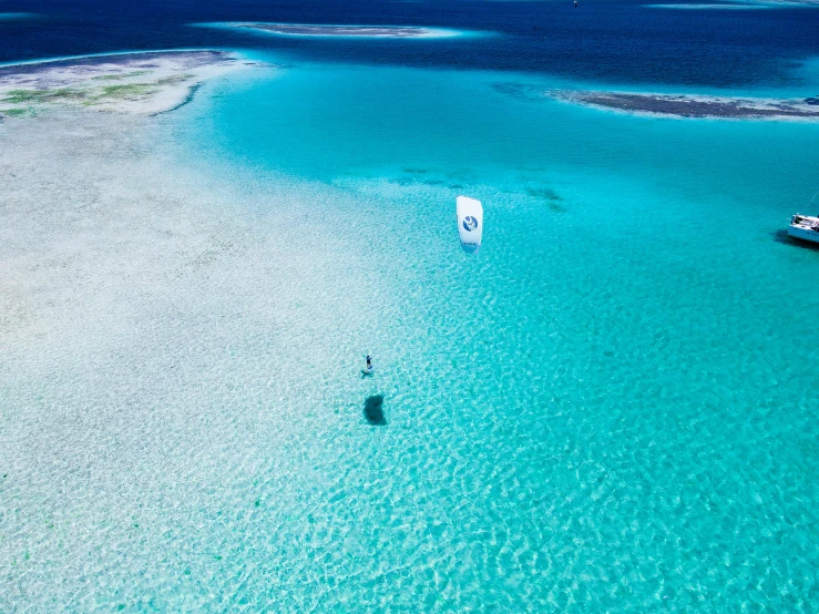 three boats in the water near some sandy beach