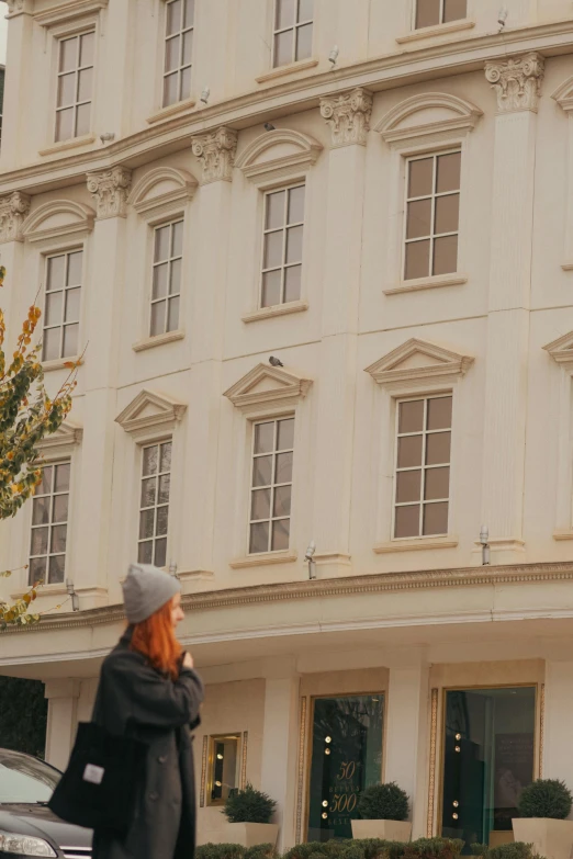 a woman walking on the street by an old building