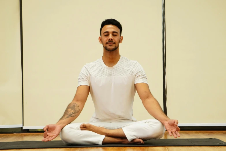 a man doing yoga and meditation on a yoga mat