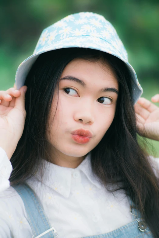 a woman wearing a light blue sunhat covering her face