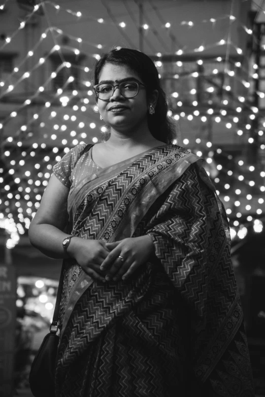 a woman standing in front of a building wearing a sari