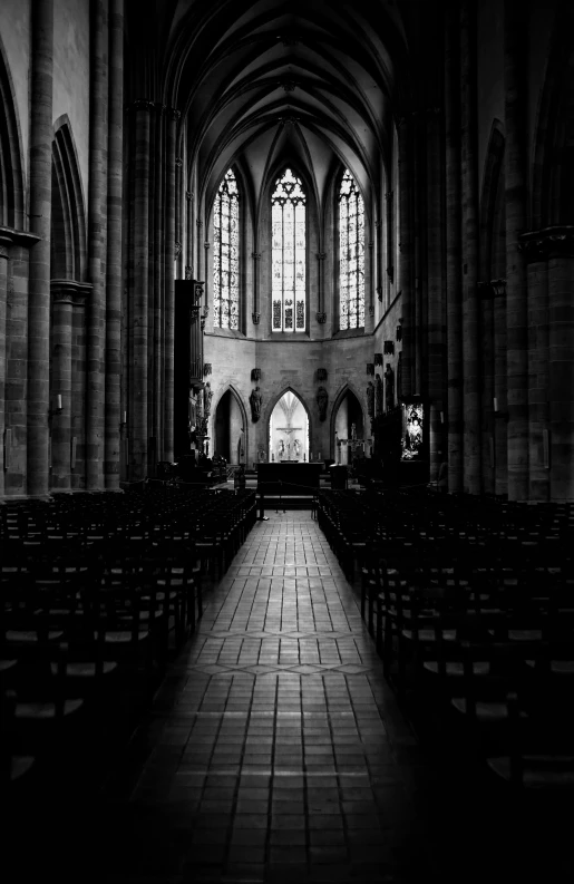 a large church filled with stone rows of pews