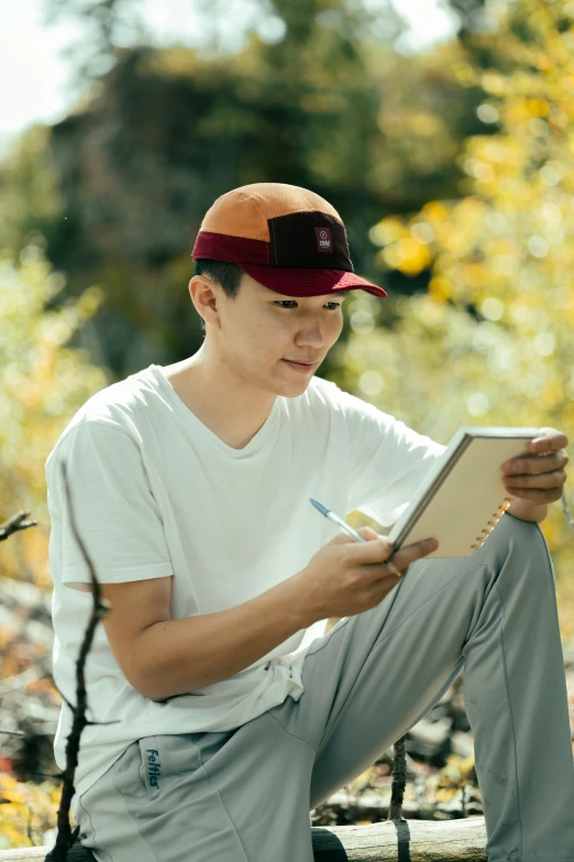 a man sitting on a bench writing on a clipboard