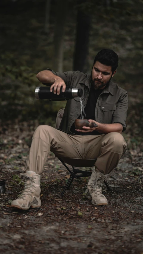 man sitting in the forest while looking through an object