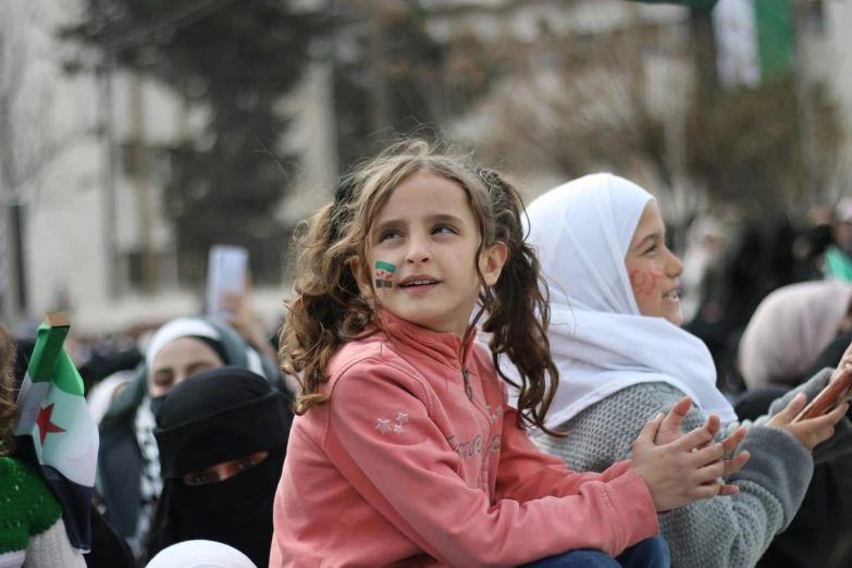 a little girl sitting on top of a man