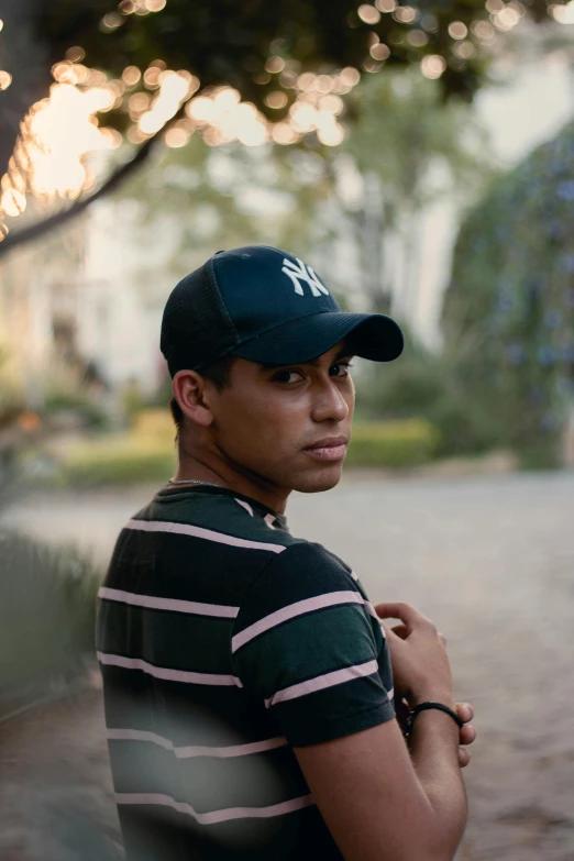 a man wearing a green and white striped shirt and cap