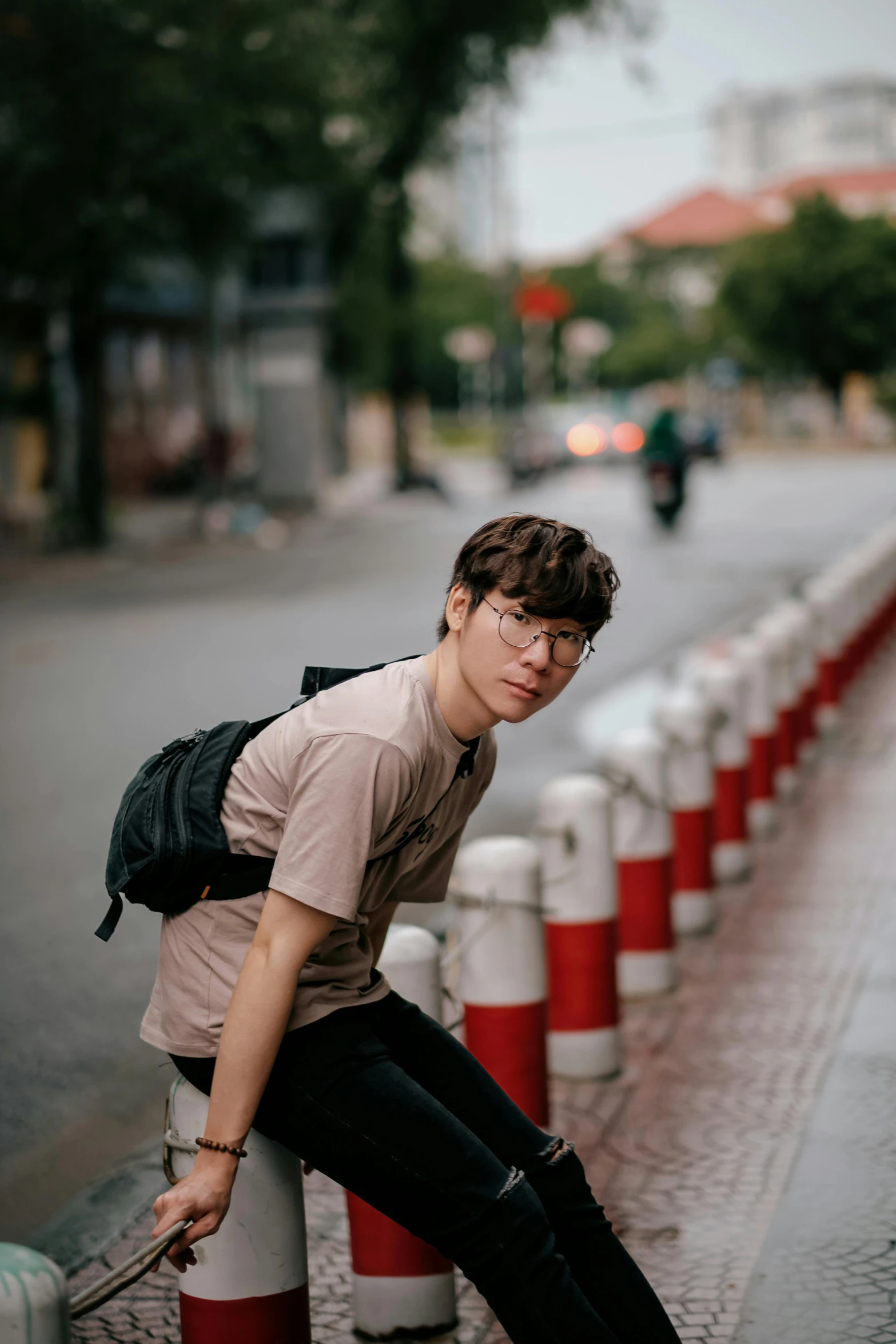 a person with a backpack and glasses sitting on top of a fire hydrant