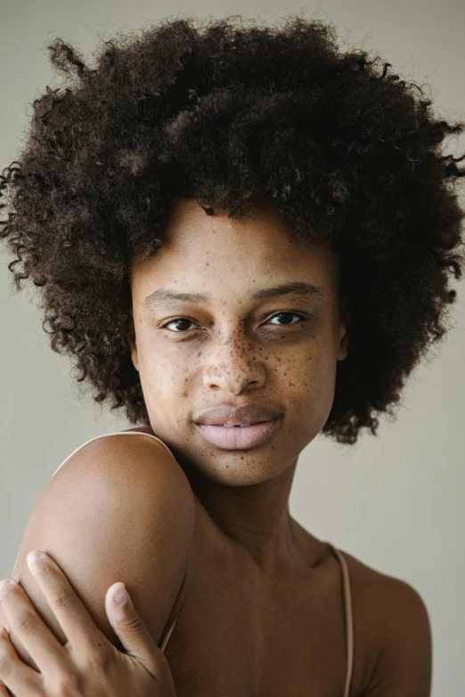 a woman with big afro holding her shoulder