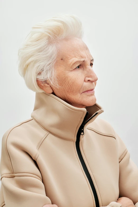 an old lady is dressed in beige with a black zipper