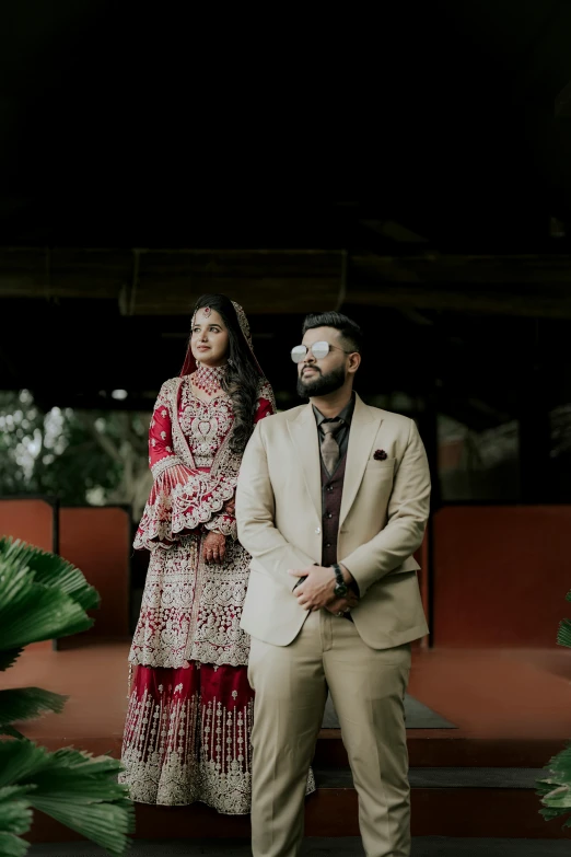 two people standing next to each other on a grass covered ground