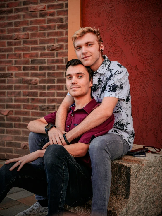 two guys sitting on the concrete near each other