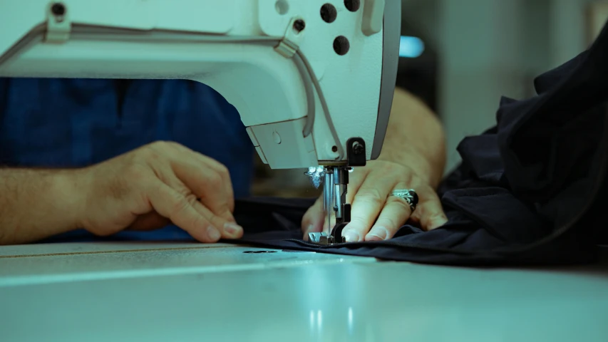 a person uses a sewing machine to stitch soing