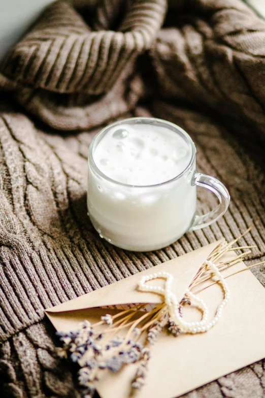 a glass cup of milk on top of a card