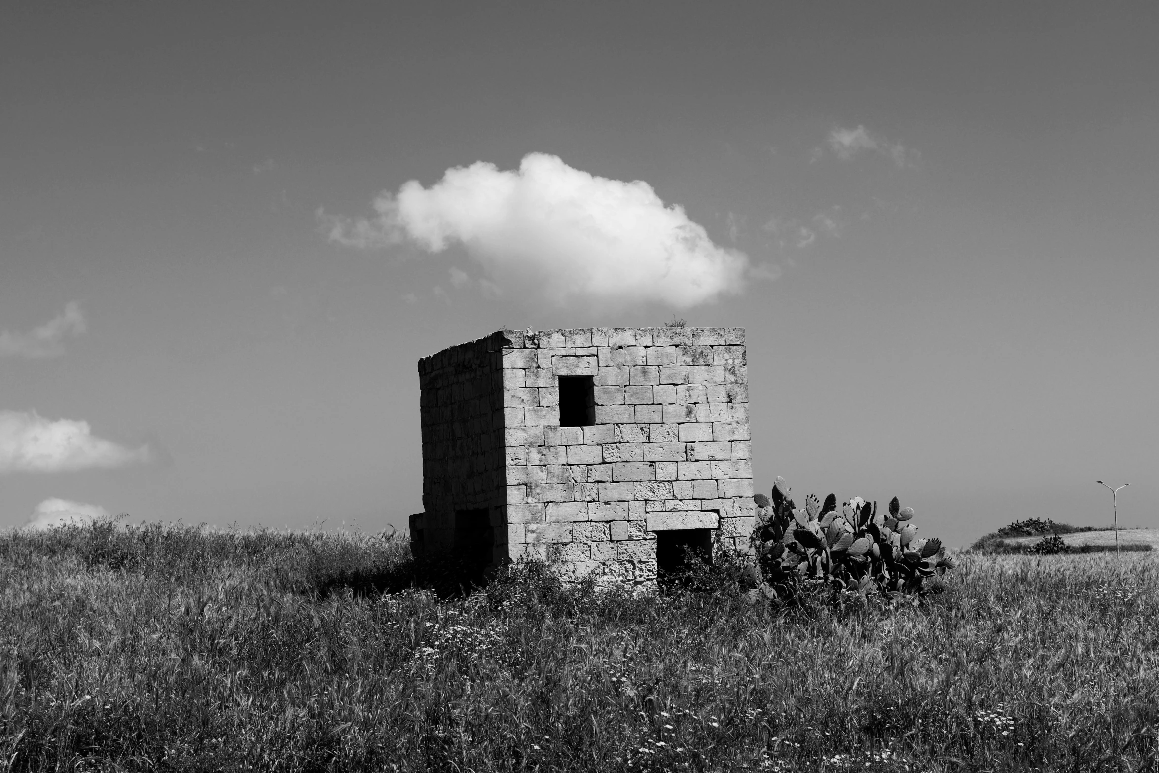 a black and white po of an old building that is out in a field