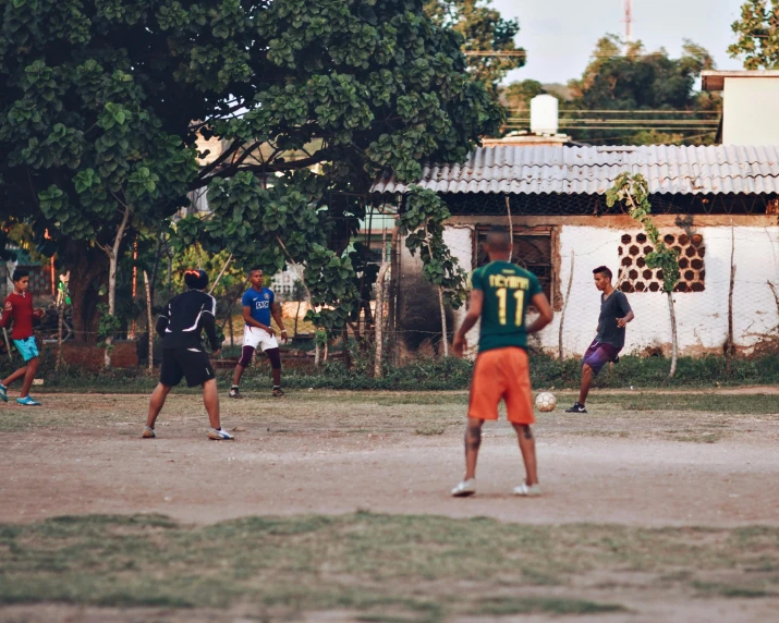 a group of young men playing soccer outside in the street