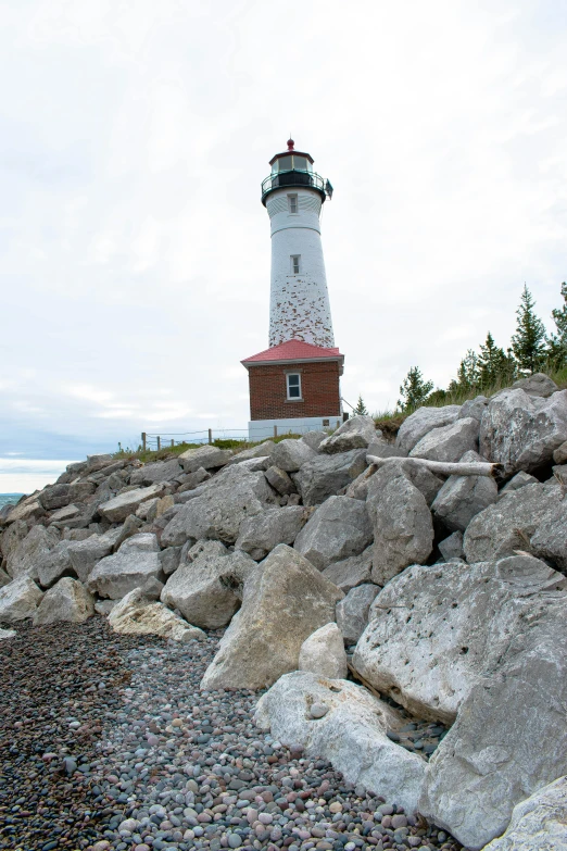 the light house is in the middle of a bunch of rocks