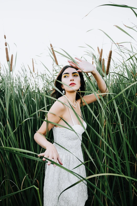 a woman in white dress standing in grass