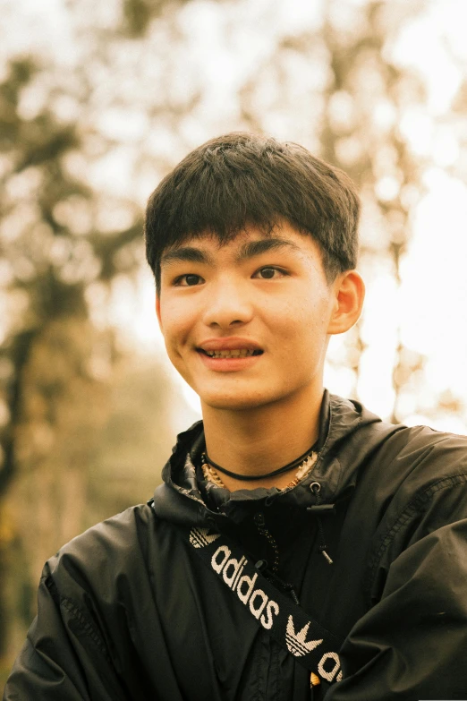 young asian boy in black hoodie posing for the camera