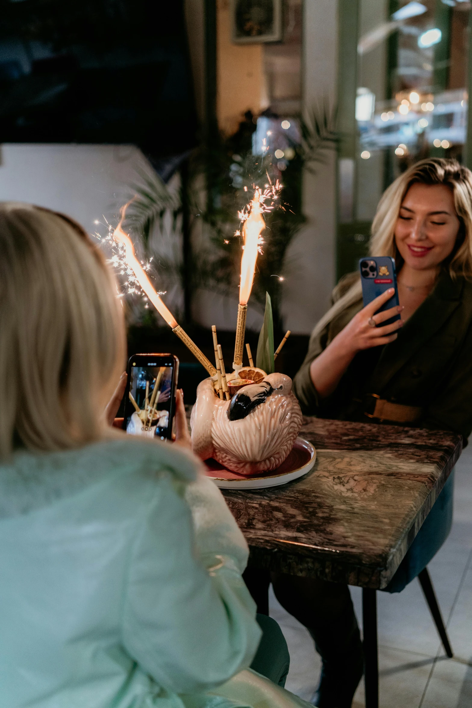 a woman using her cell phone and lights a sparkler