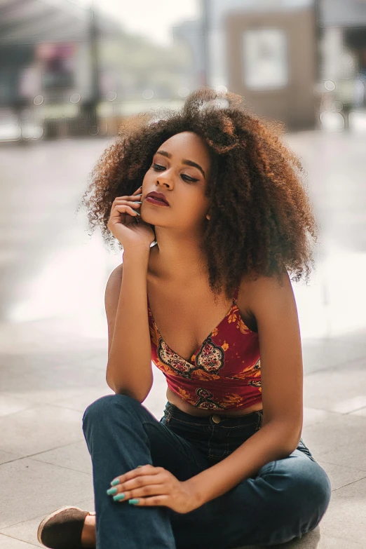 a woman sitting on the ground in a city square