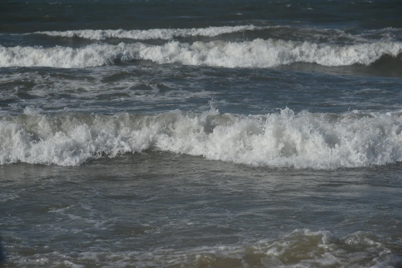 a person with a surfboard stands in the ocean