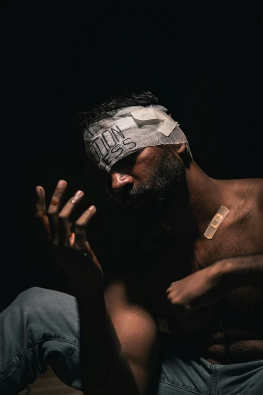 man with a bandaged forehead is praying