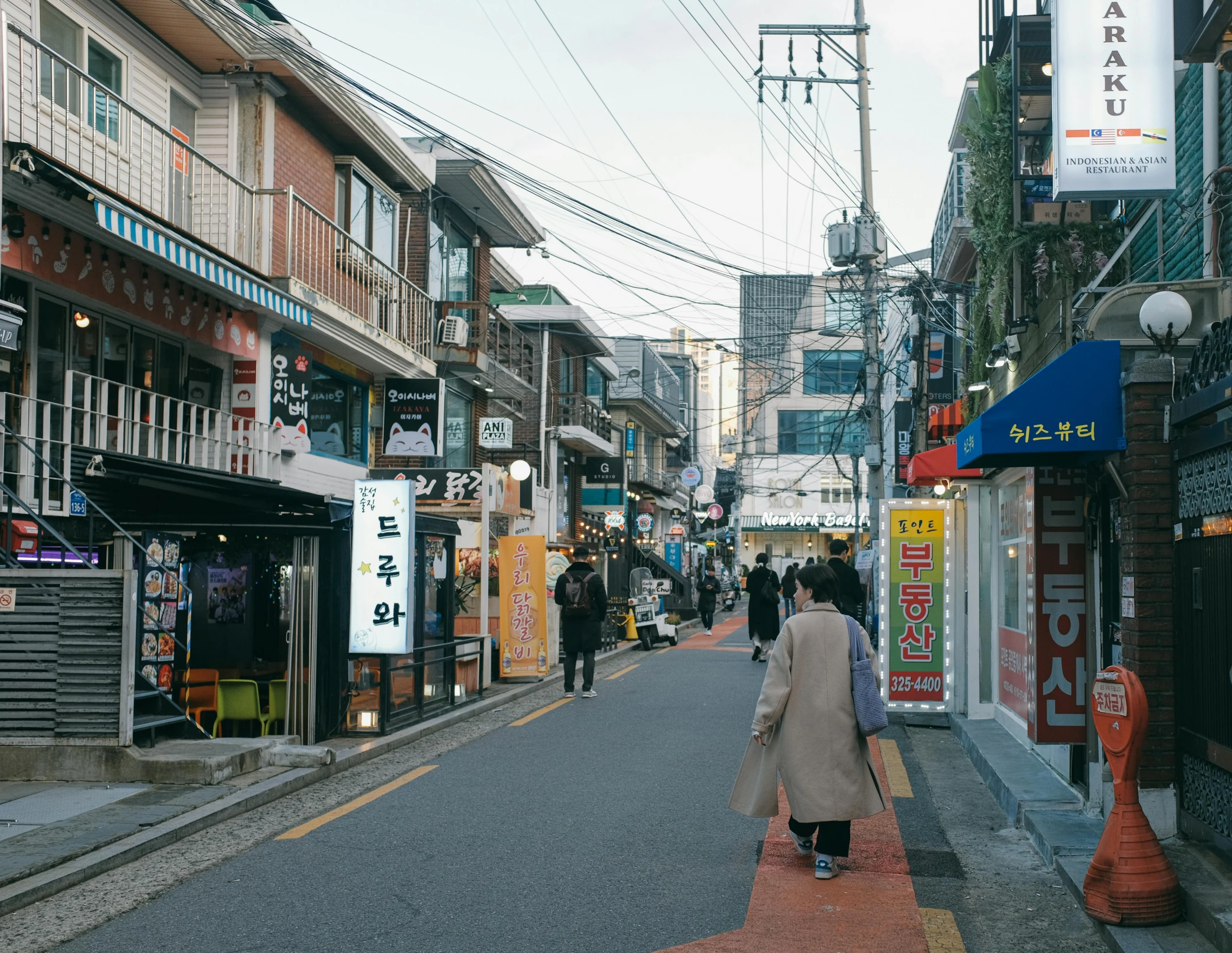 people are walking down an alley near stores