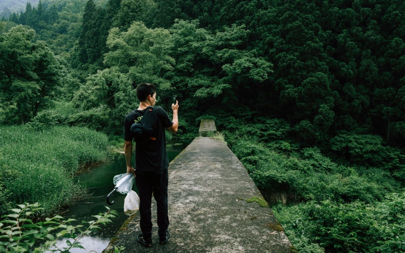 the man is walking down a path to the mountains