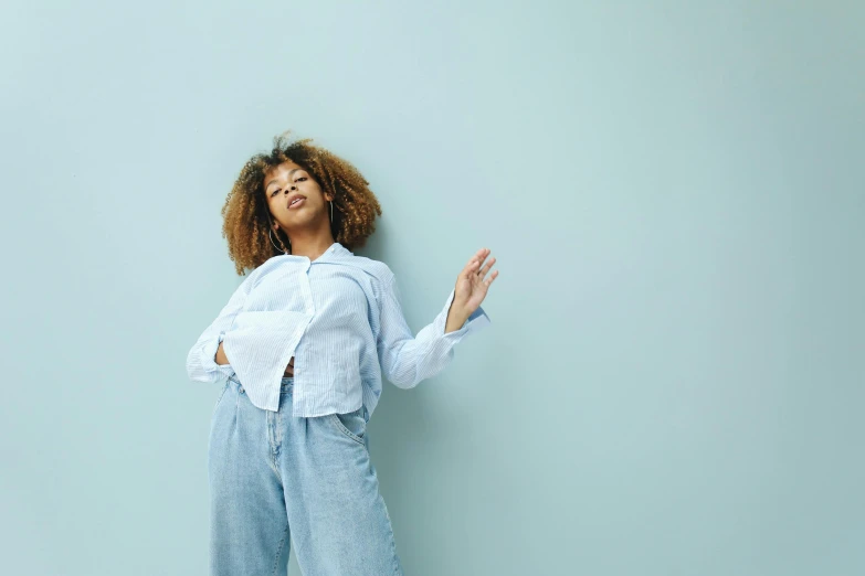 the woman is posing by the blue wall