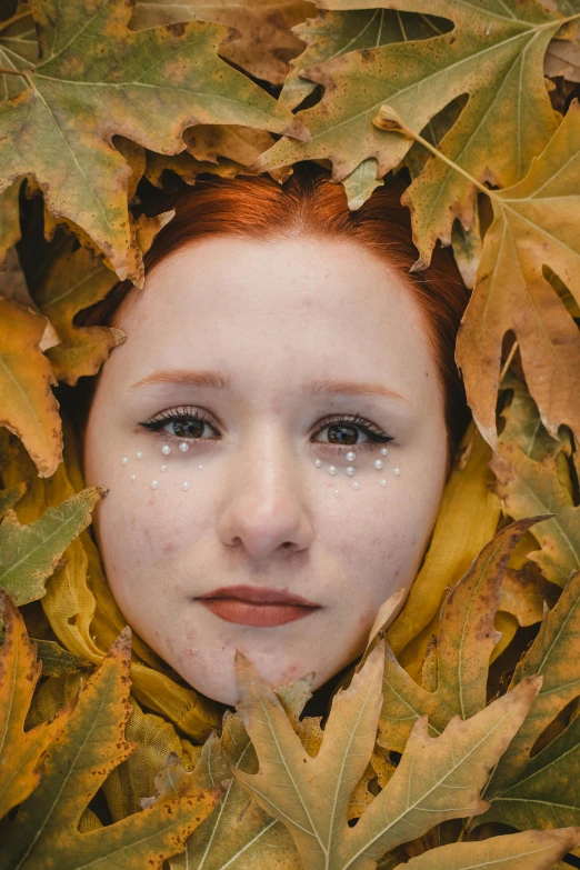 a little girl that is hiding among leaves