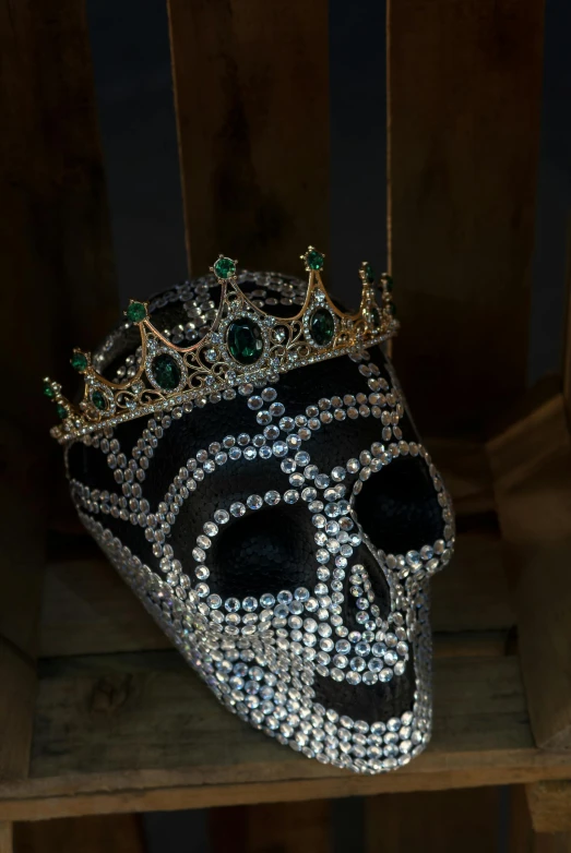 a black and white skull mask with green jewels