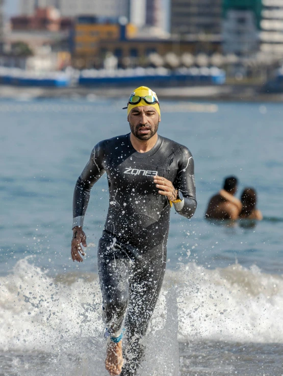 a man with goggles on, running in the ocean