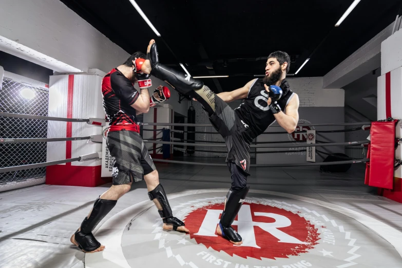 two fighters in an indoor ring with one kick hitting the other