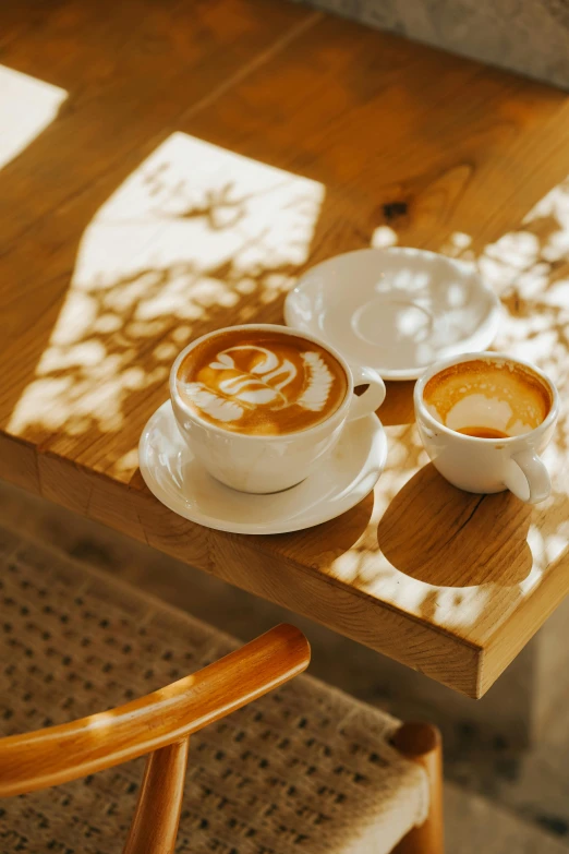 a table topped with cups and saucers filled with liquid