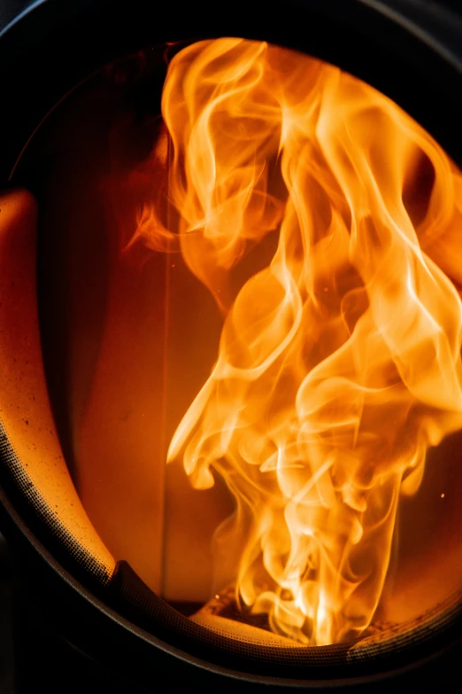 a fireplace with flames and a small wood stove top