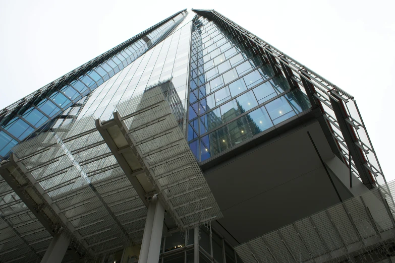 a very tall glass building with an object above