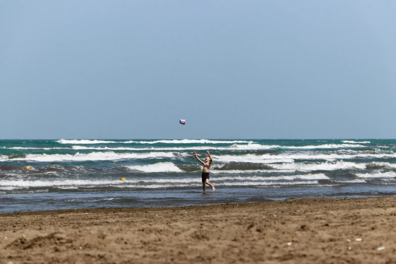 man holding onto surfboard standing in ocean waves