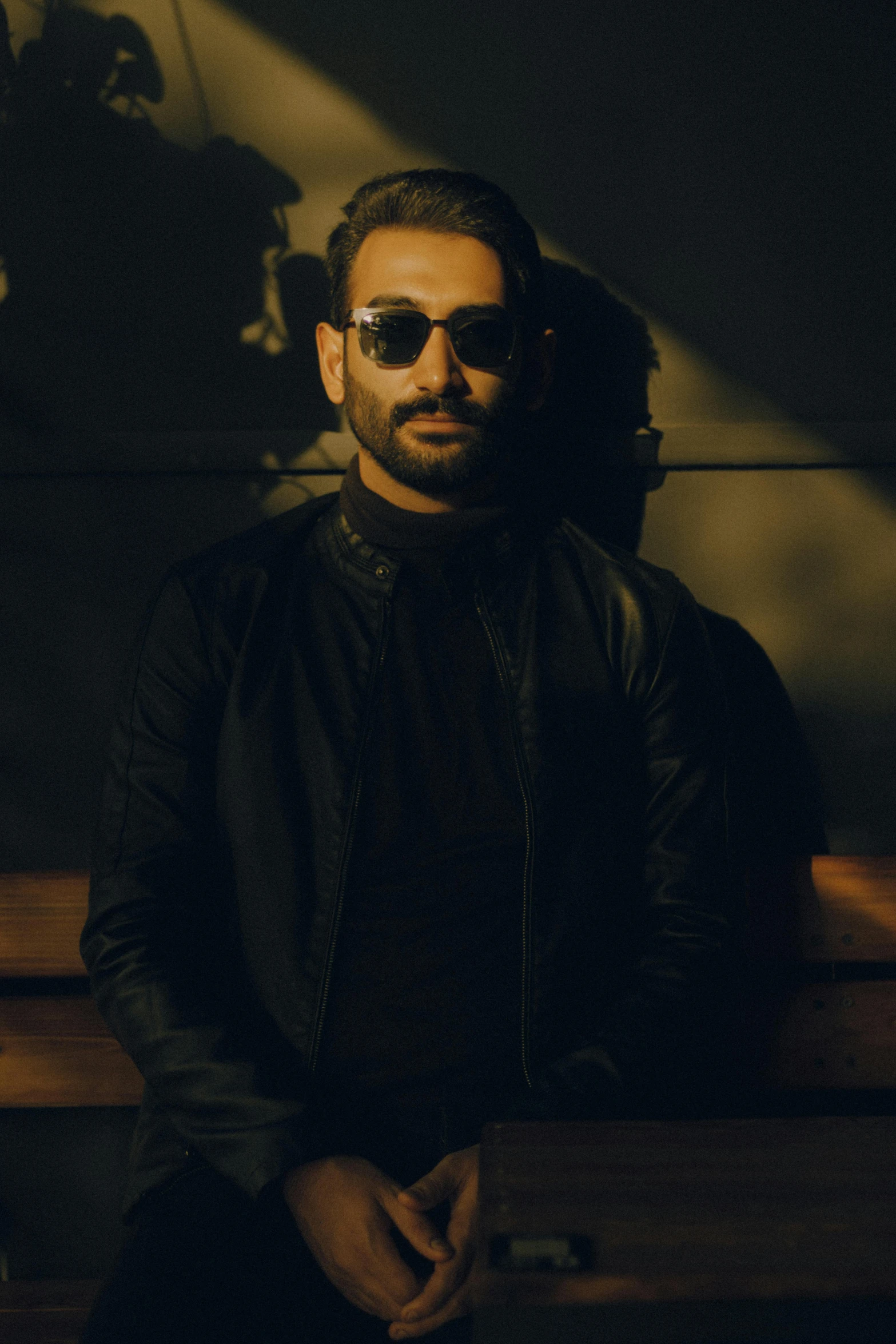 a man with sunglasses and a black jacket