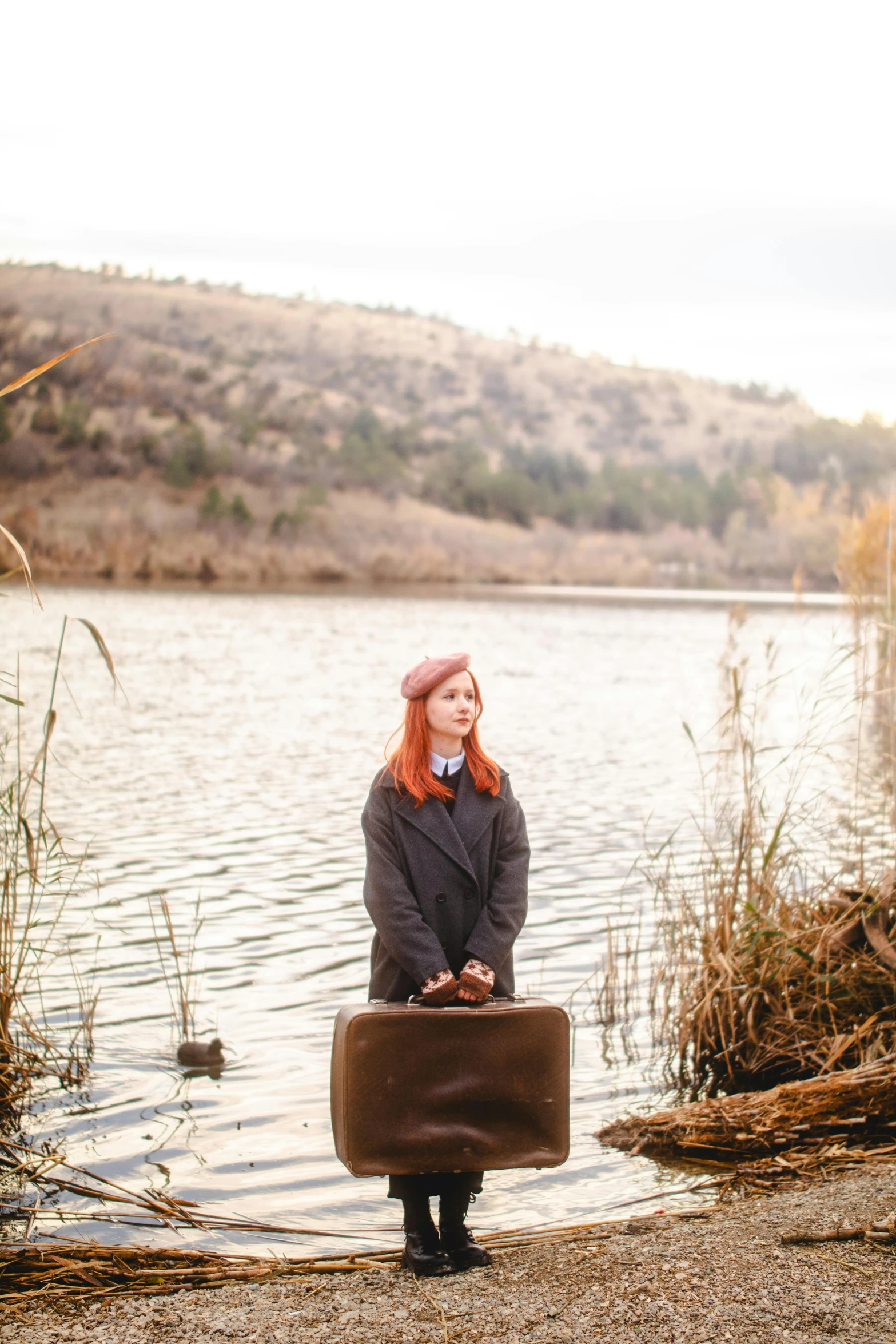 a woman posing with a briefcase in front of a lake
