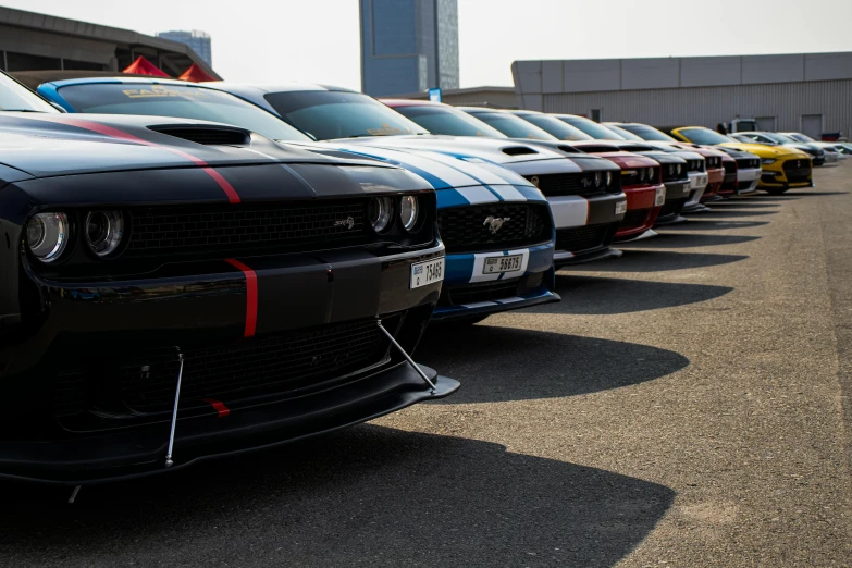 the cars parked side by side have racing stripes on them