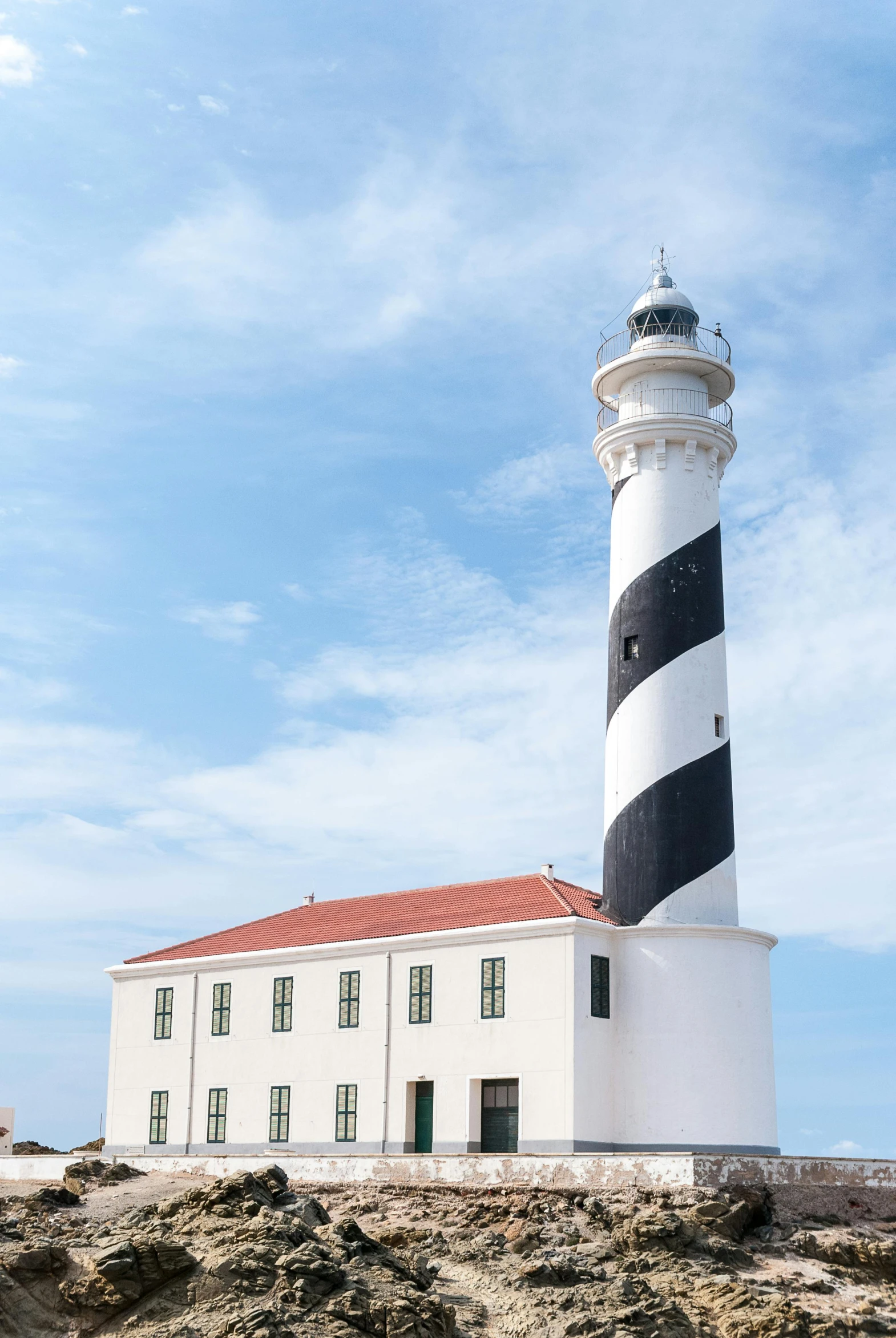 the lighthouse has a red roof and black and white stripes