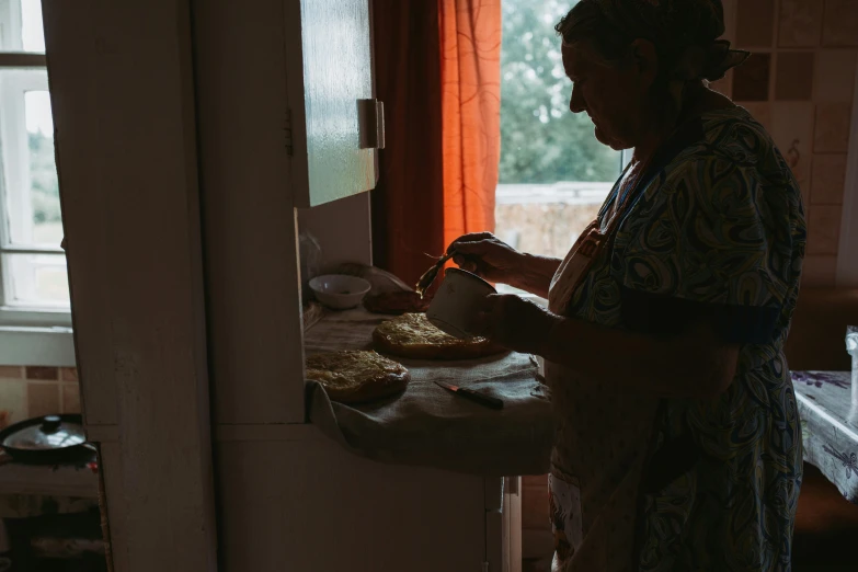 a woman in a kitchen cooking soing on a stove