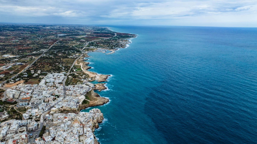 an aerial view of the coastline and blue waters