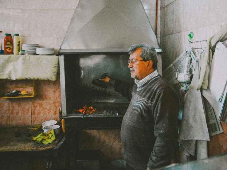 a man standing next to an oven in a kitchen